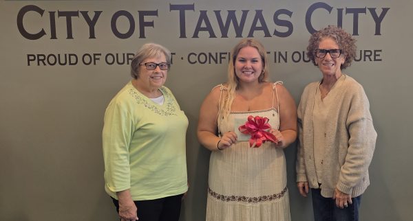 Empowering Youth with Engagement Strategies (EYES) participant Olivia Wight-McMurray holding scholarship envelope between Chair Mary Doak and Secretary Tracy Stevelinck